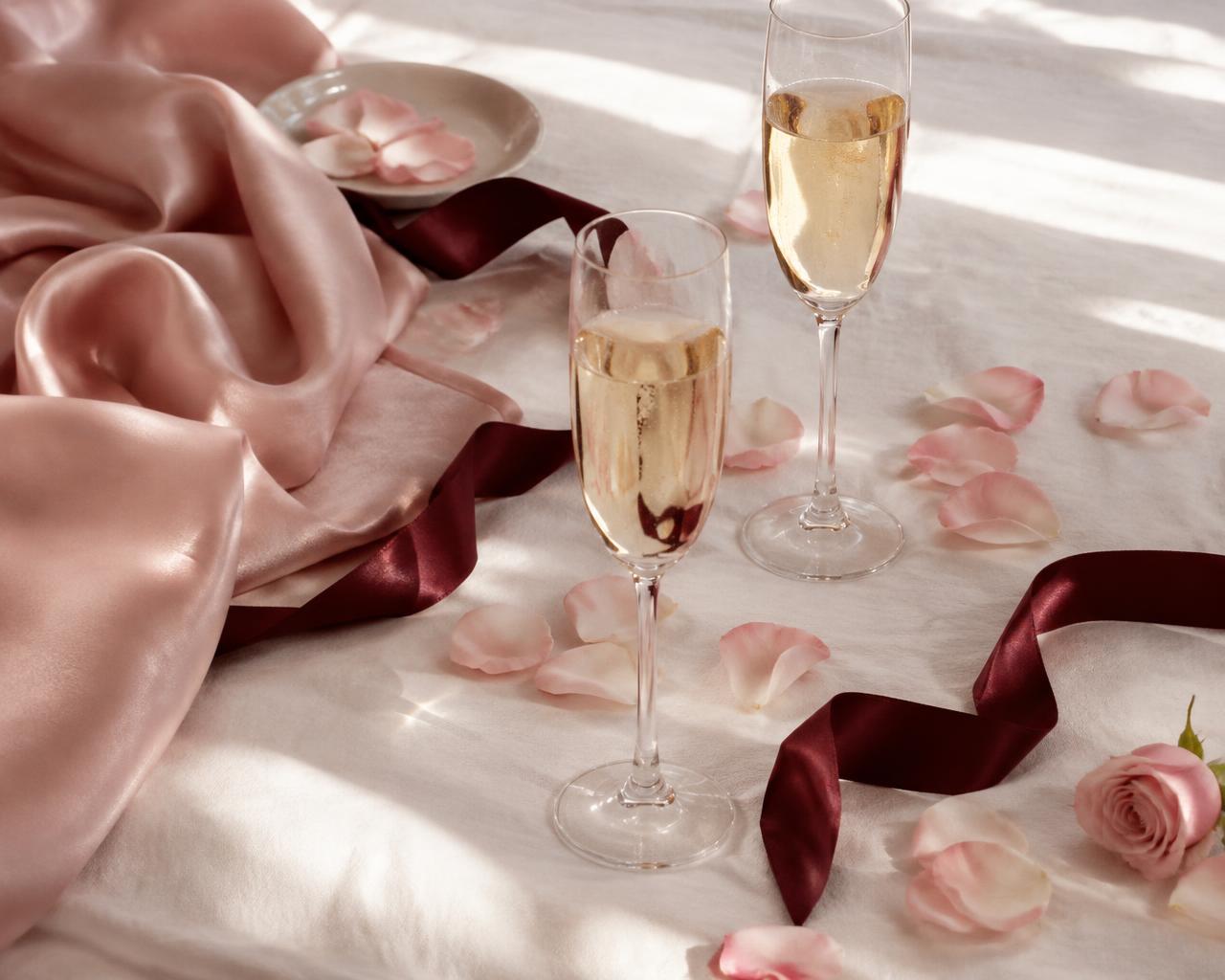 Two champagne glasses with rose petals